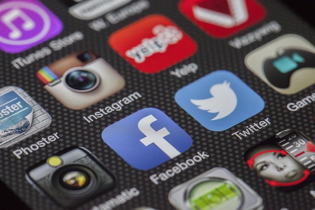 An image of a mobile phone screen with social media app icons including Facebook, Twitter, and Instagram