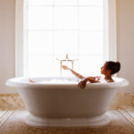 Woman enjoying bath in an interior designer worthy setting